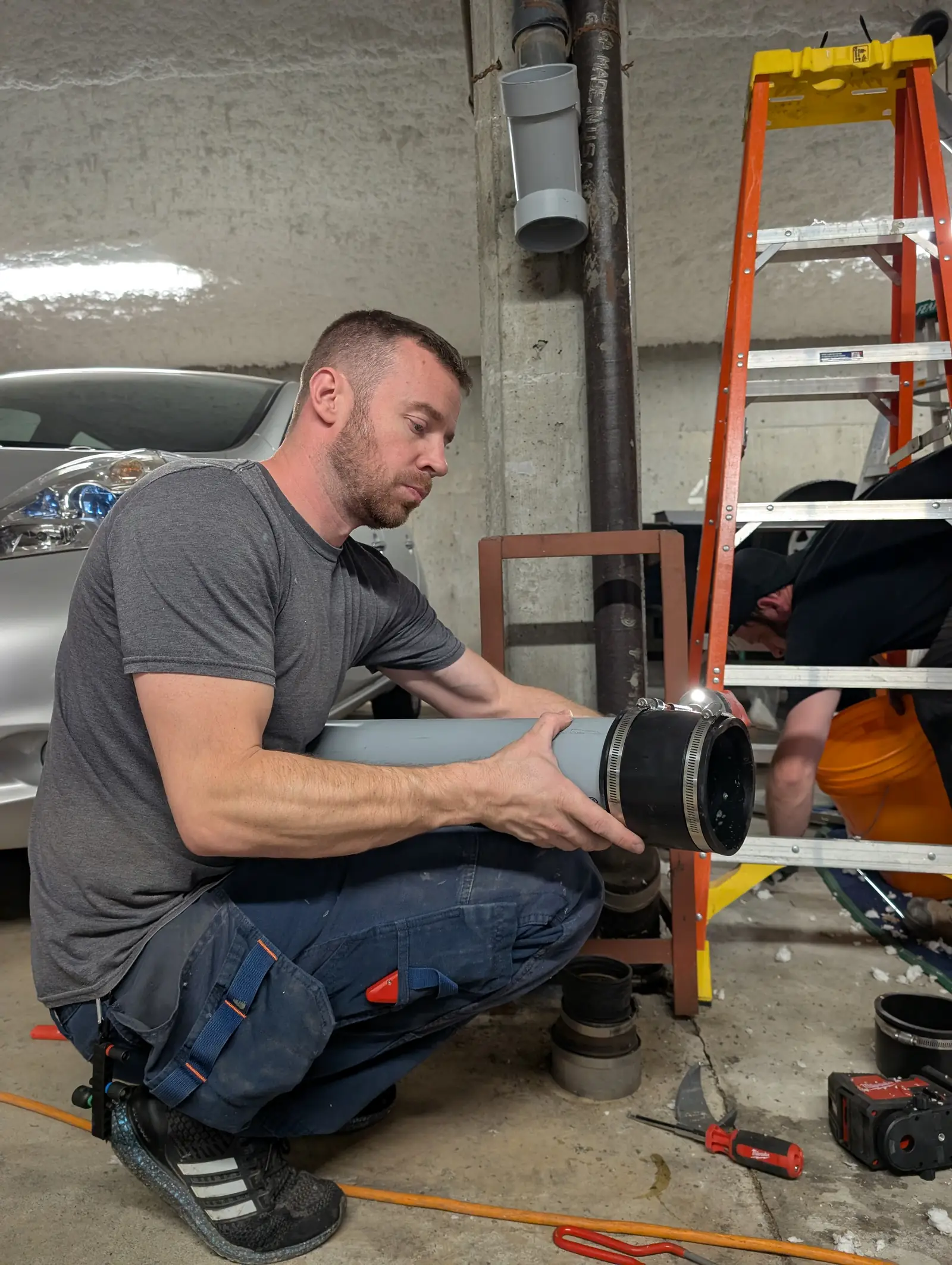 Jon, owner of Paradigm Services, repairing a spraying kitchen-sink leak