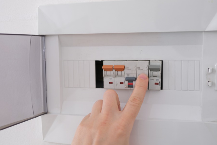 A person switching an electrical breakers.
